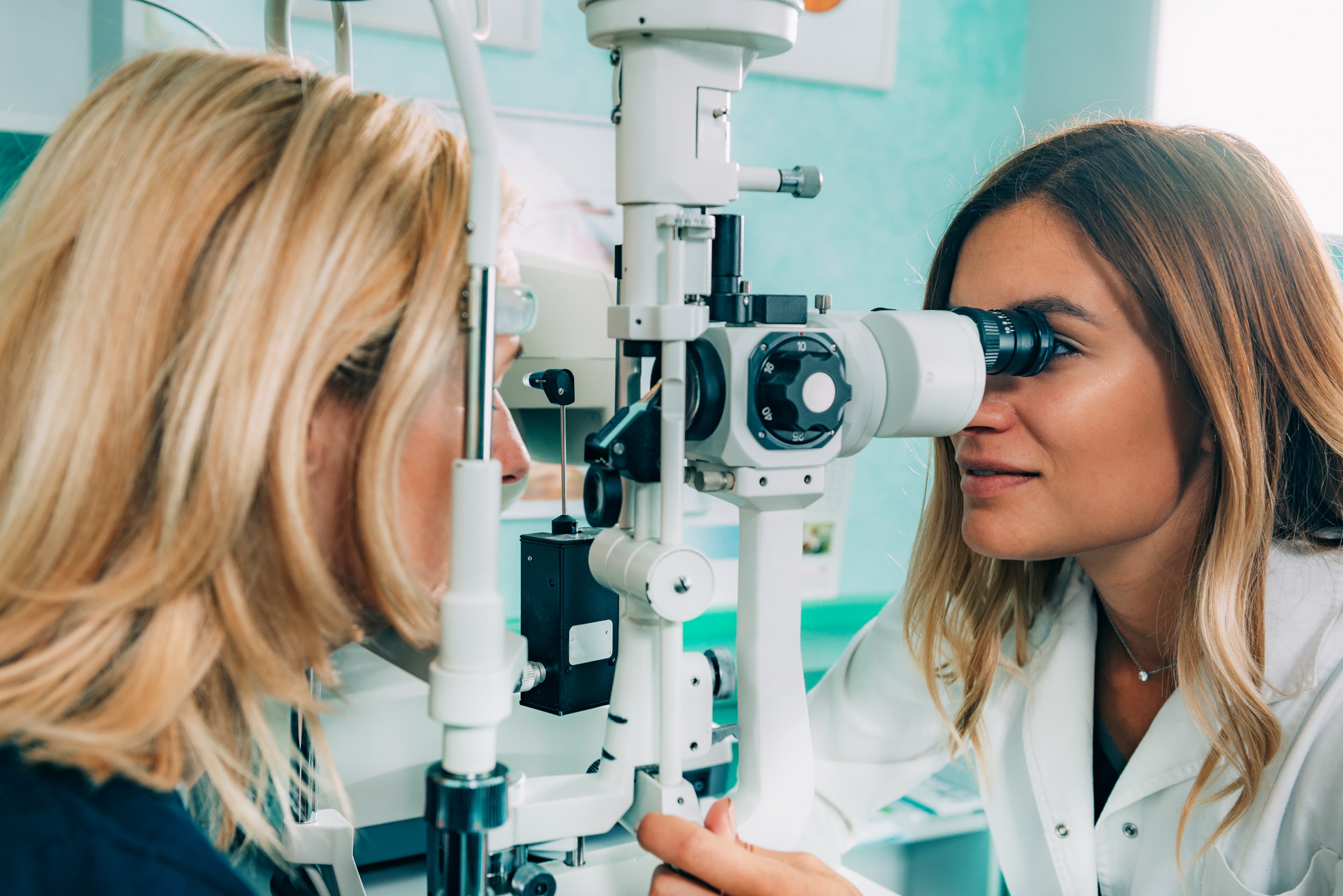 Optometrist performing an eye exam with slit lamp equipment
